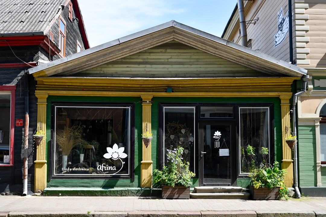 A quaint storefront with yellow and green trim